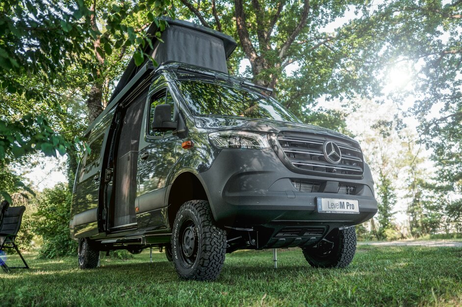 Gray camper van with raised pop-up roof and open side sliding door. | © AL-KO VT